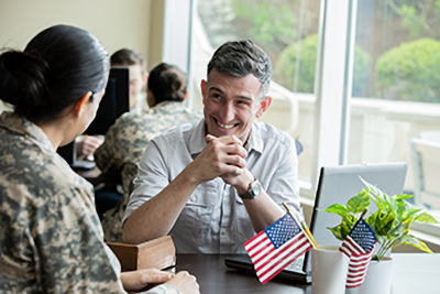 service member and civilian talking at a table
